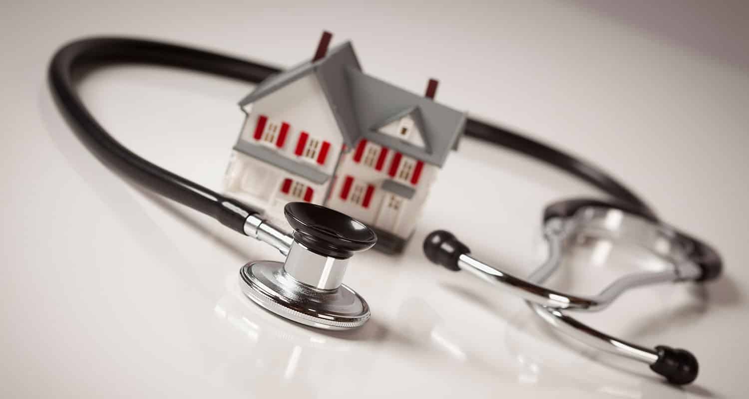 Maison miniature entouré par un stétoscope