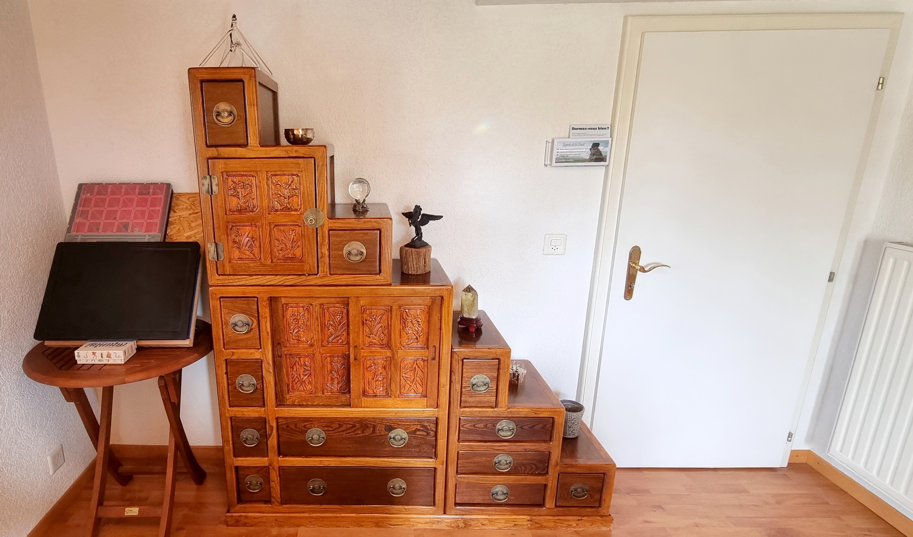 caisse avec les pierres de soins à gauche, meuble escalier au centre, porte d&apos;accès à droite